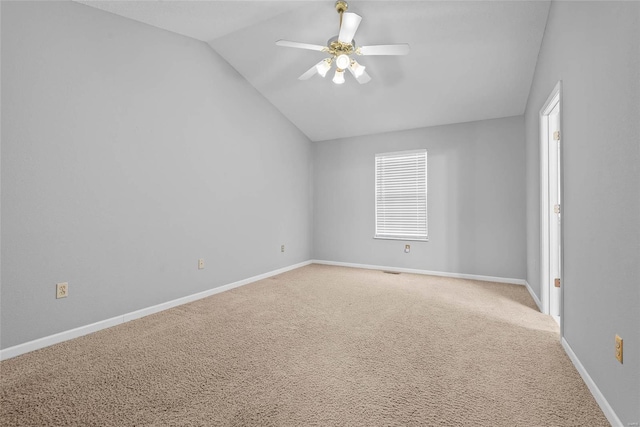 empty room featuring vaulted ceiling, carpet, a ceiling fan, and baseboards