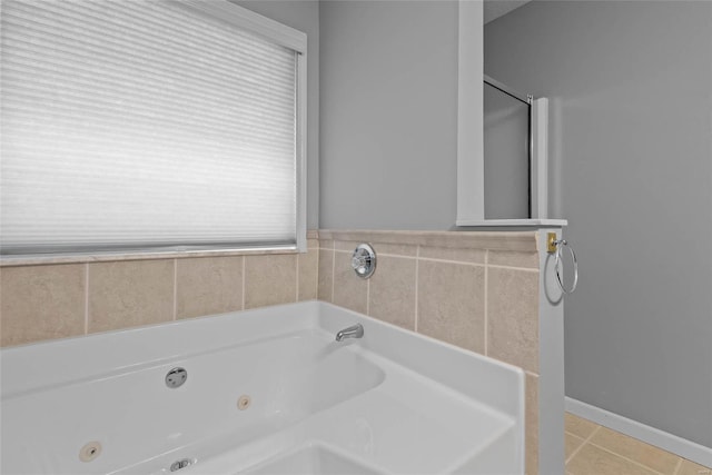 bathroom with a jetted tub, tile patterned flooring, and baseboards