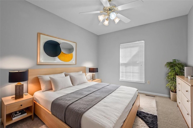 bedroom featuring light carpet, a ceiling fan, visible vents, and baseboards