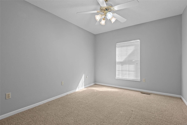 unfurnished room with light carpet, baseboards, visible vents, and a ceiling fan