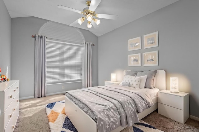 carpeted bedroom with ceiling fan, baseboards, and vaulted ceiling