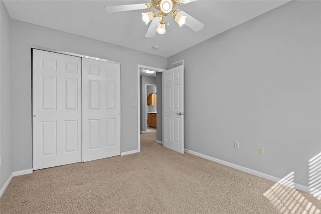 unfurnished bedroom with carpet floors, baseboards, and a closet