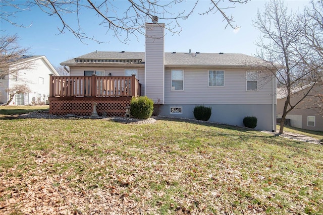 rear view of property with a chimney, a lawn, and a wooden deck