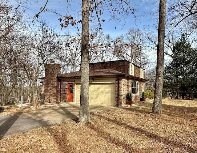 view of side of property with mansard roof, a garage, brick siding, a shingled roof, and driveway