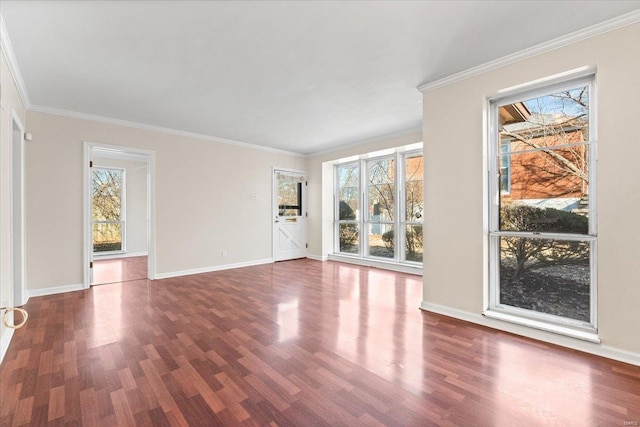 unfurnished living room featuring crown molding, baseboards, and wood finished floors