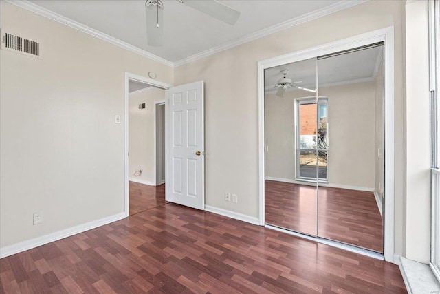 unfurnished bedroom with wood finished floors, visible vents, baseboards, ornamental molding, and a closet