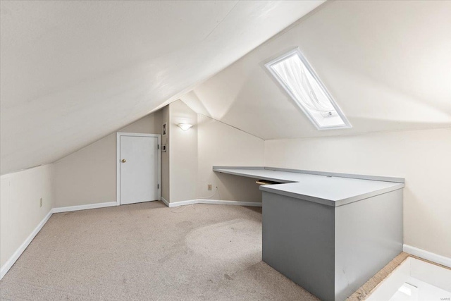 bonus room with lofted ceiling with skylight, carpet flooring, and baseboards