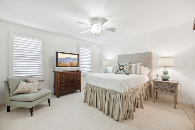 bedroom featuring baseboards, light carpet, and a ceiling fan