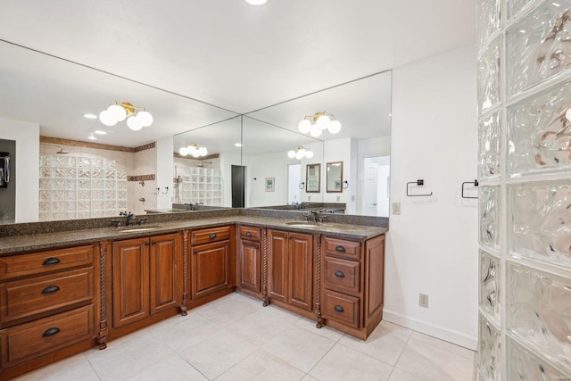 full bath with a sink, double vanity, and tile patterned floors