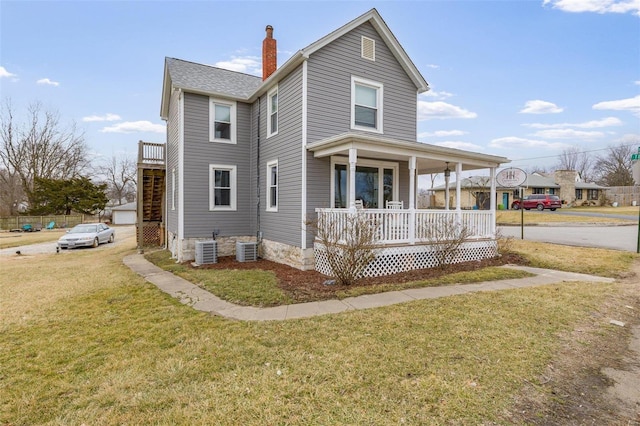 view of front of property featuring covered porch, a chimney, a front lawn, and central AC unit