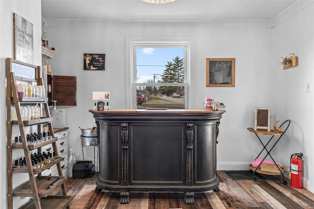 interior details featuring crown molding, baseboards, a fire extinguisher, and wood finished floors