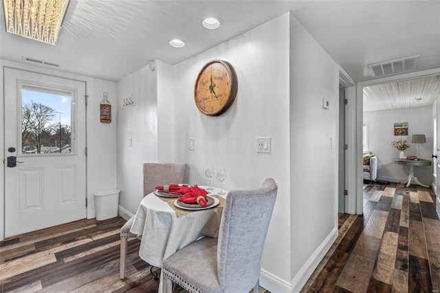 dining room featuring wood finished floors, visible vents, and baseboards