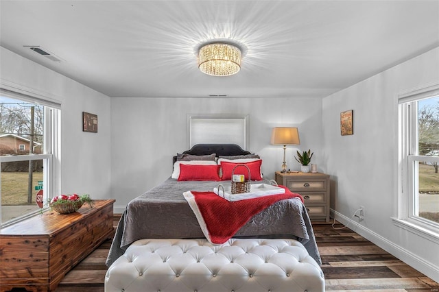 bedroom featuring wood finished floors, visible vents, and baseboards