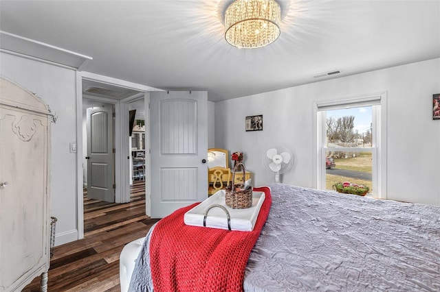 bedroom featuring a chandelier, wood finished floors, and visible vents