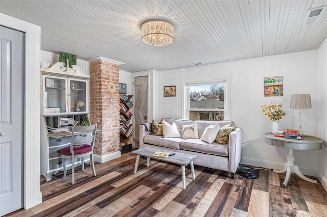 living room with visible vents, baseboards, and wood finished floors