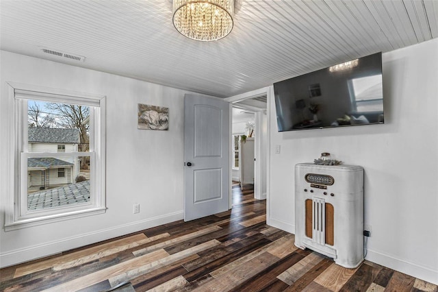 living area with a chandelier, dark wood-style flooring, visible vents, and baseboards