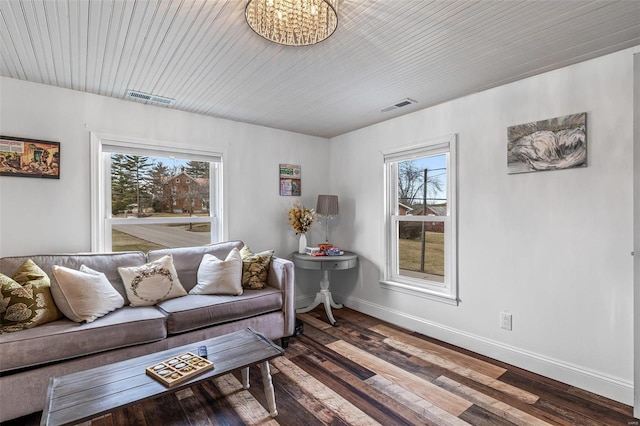 living room with wood finished floors, visible vents, and baseboards