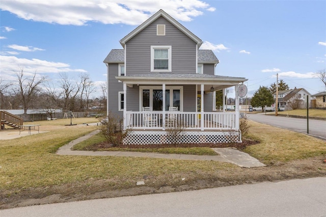 view of front of home featuring a shingled roof, a front yard, and covered porch