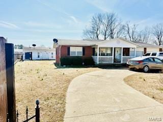 ranch-style home with driveway, a porch, and fence