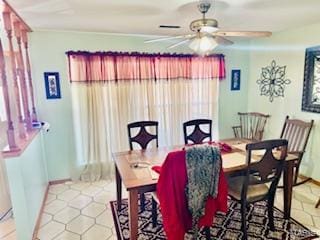 dining space with tile patterned flooring, ceiling fan, and baseboards