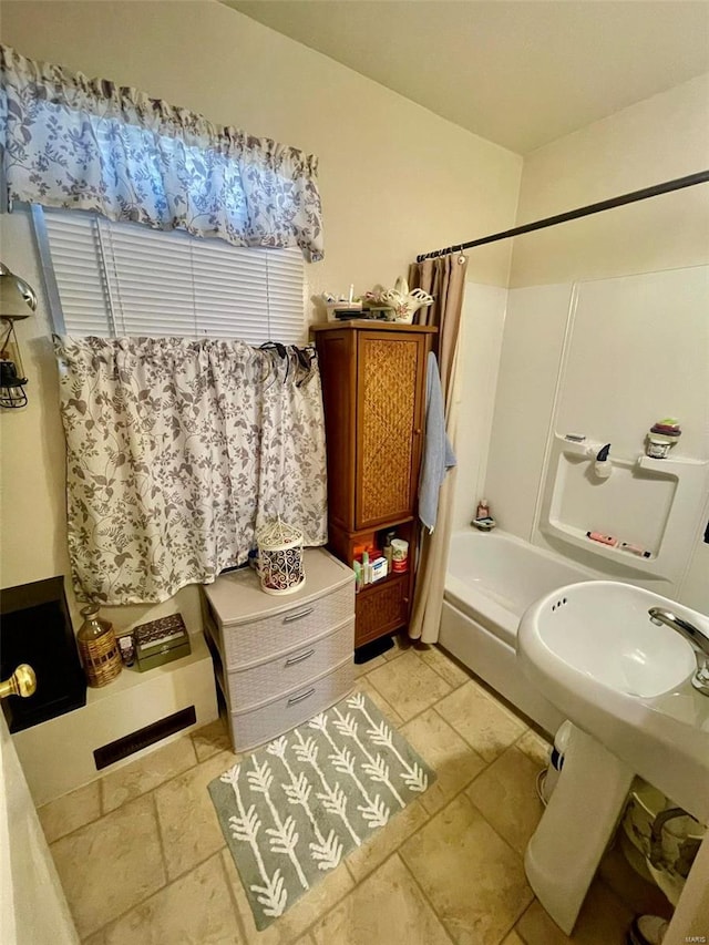 bathroom featuring shower / tub combo and stone tile flooring