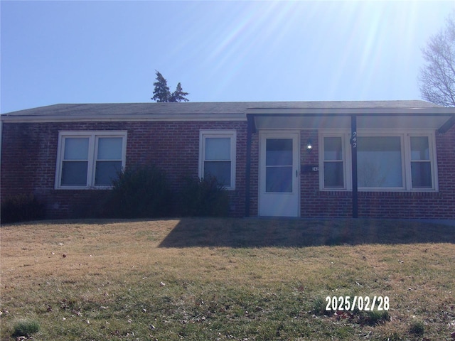 ranch-style house with a front yard and brick siding