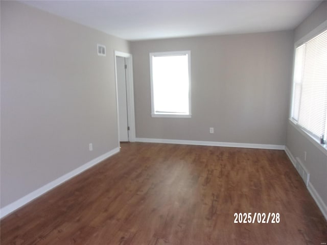 spare room featuring baseboards, visible vents, and a wealth of natural light