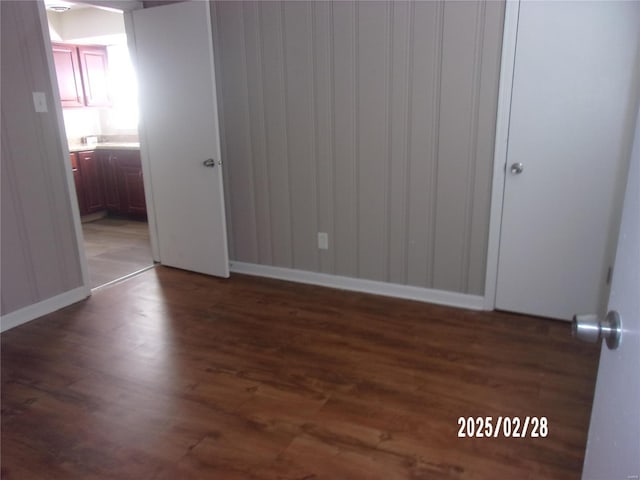 empty room with wood finished floors and baseboards