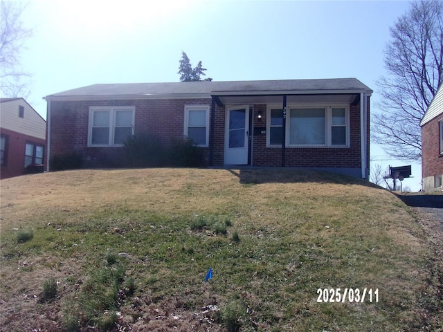 view of front of house featuring brick siding and a front lawn