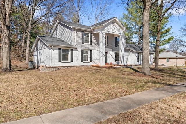 neoclassical home featuring a front yard, central AC, and brick siding