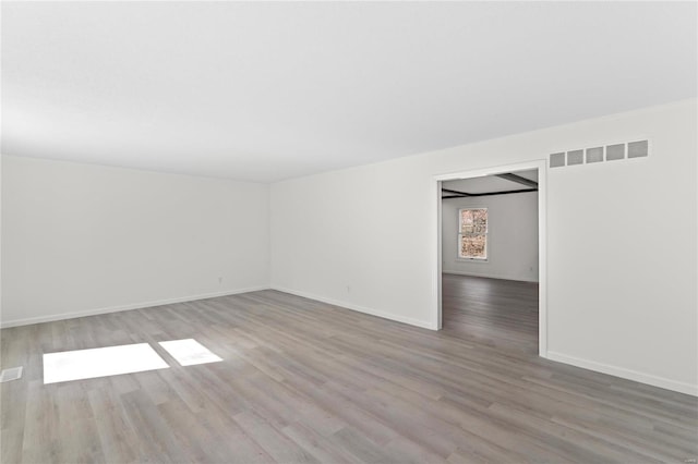 unfurnished room with visible vents, baseboards, and wood finished floors