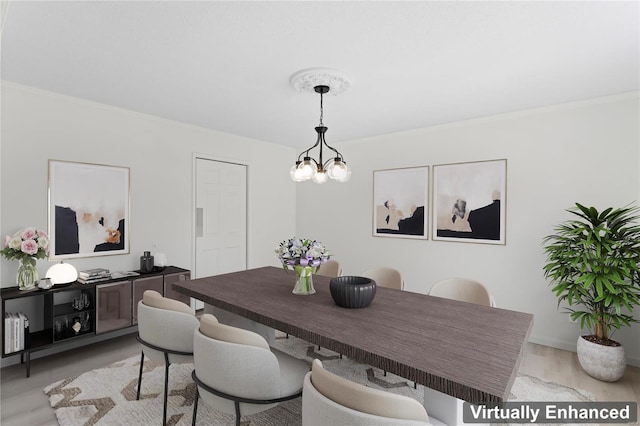 dining room featuring crown molding, a notable chandelier, and light wood finished floors