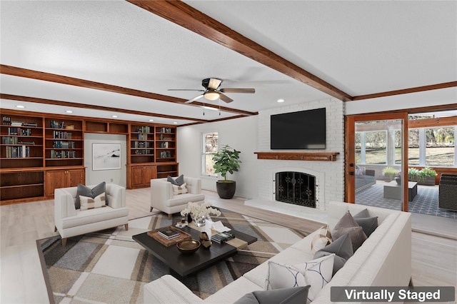 living room with beam ceiling, a fireplace, a textured ceiling, and ceiling fan