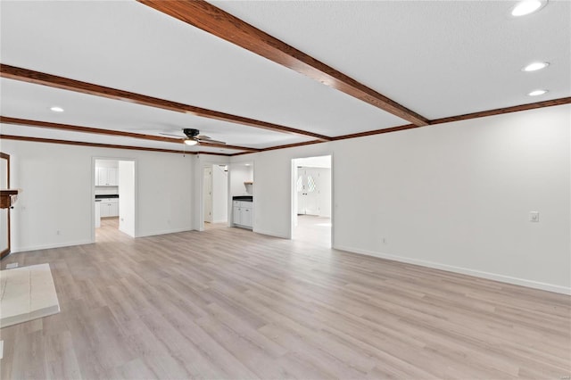 unfurnished living room with ceiling fan, baseboards, ornamental molding, light wood finished floors, and beamed ceiling