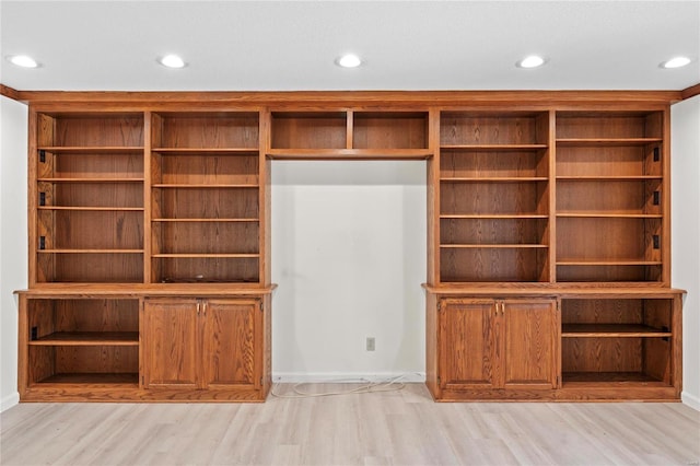 unfurnished living room featuring baseboards, recessed lighting, and light wood-style floors