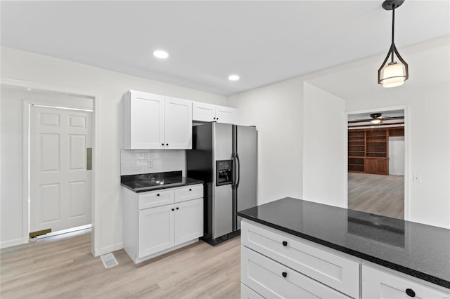 kitchen featuring decorative light fixtures, light wood finished floors, backsplash, white cabinetry, and stainless steel fridge with ice dispenser