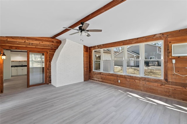 interior space featuring a wealth of natural light, wood walls, lofted ceiling with beams, and wood finished floors