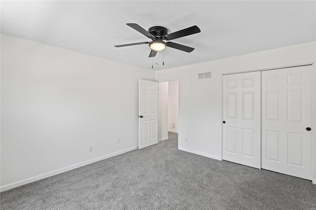 unfurnished bedroom featuring carpet floors, a ceiling fan, visible vents, baseboards, and a closet