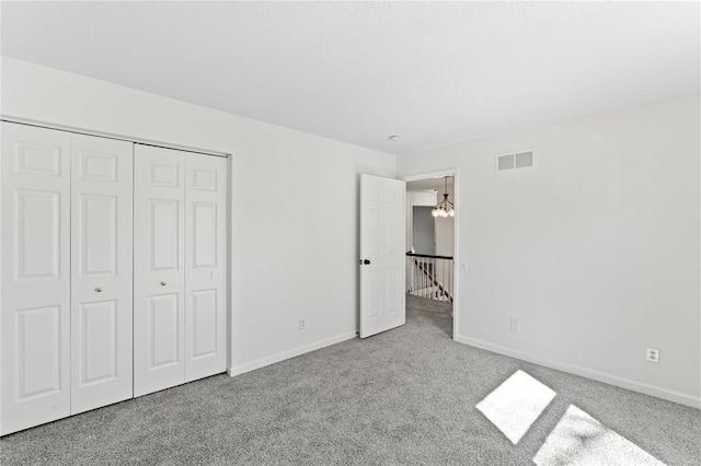 unfurnished bedroom featuring carpet, visible vents, and baseboards