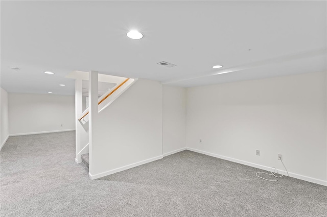 finished below grade area with visible vents, baseboards, carpet, stairs, and recessed lighting