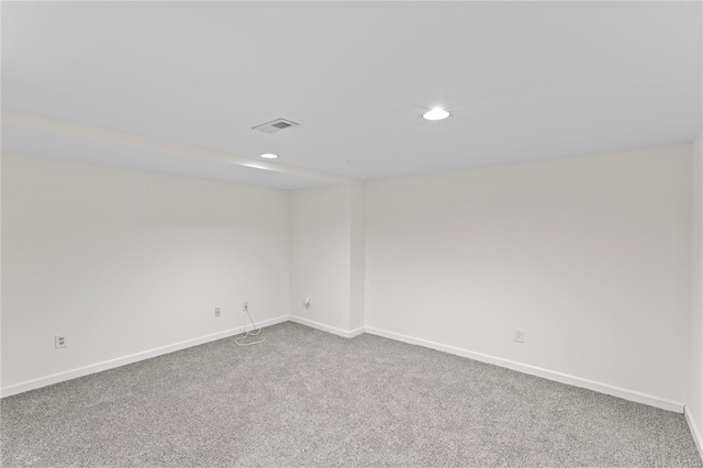 carpeted empty room with baseboards, visible vents, and recessed lighting