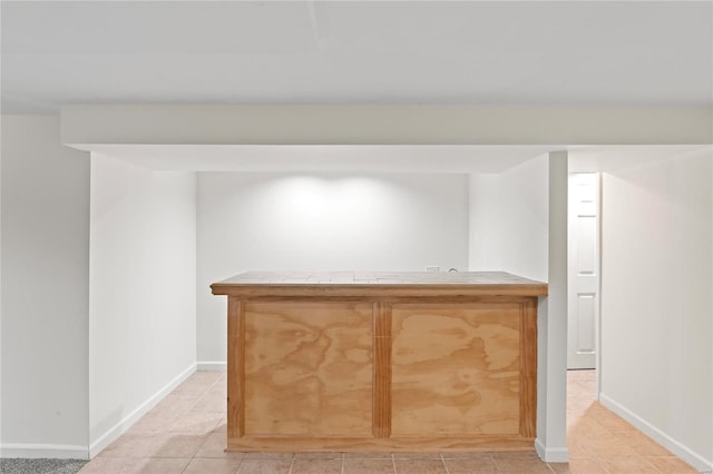 bar featuring a dry bar, light tile patterned floors, and baseboards