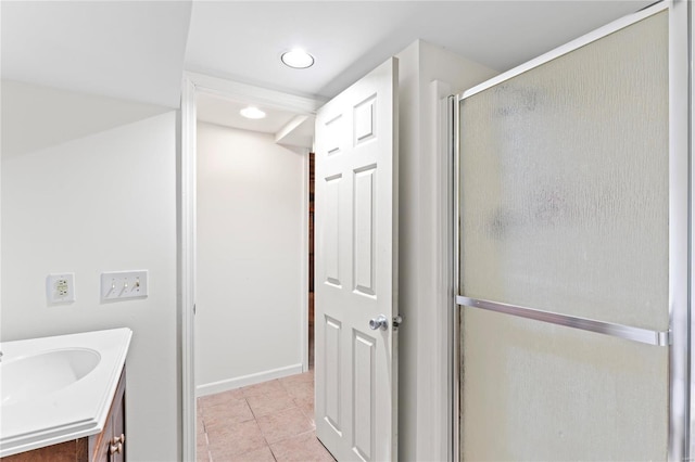 full bath featuring tile patterned flooring, a shower with shower door, vanity, and baseboards