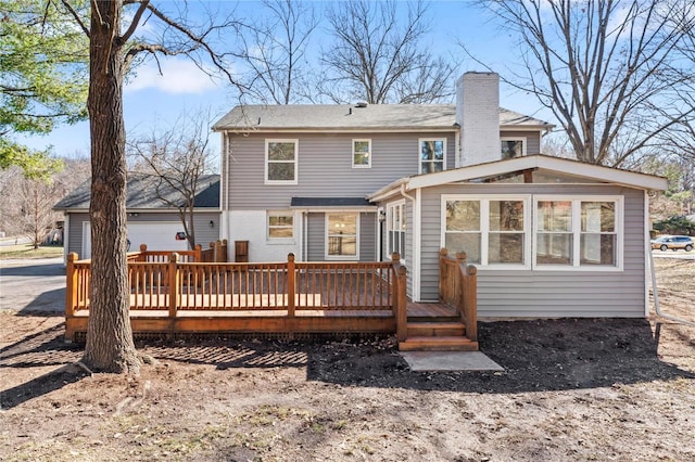 back of house featuring a chimney and a deck