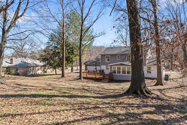 view of yard featuring a sunroom and a wooden deck