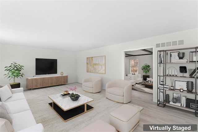 living area featuring visible vents and wood finished floors