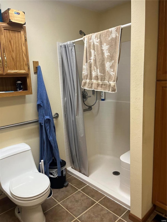 full bathroom with a stall shower, tile patterned flooring, and toilet