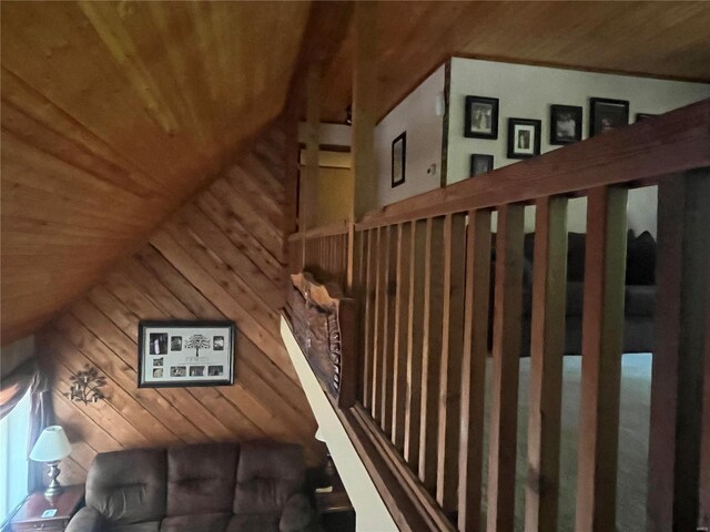 stairway featuring lofted ceiling, wood walls, and wood ceiling