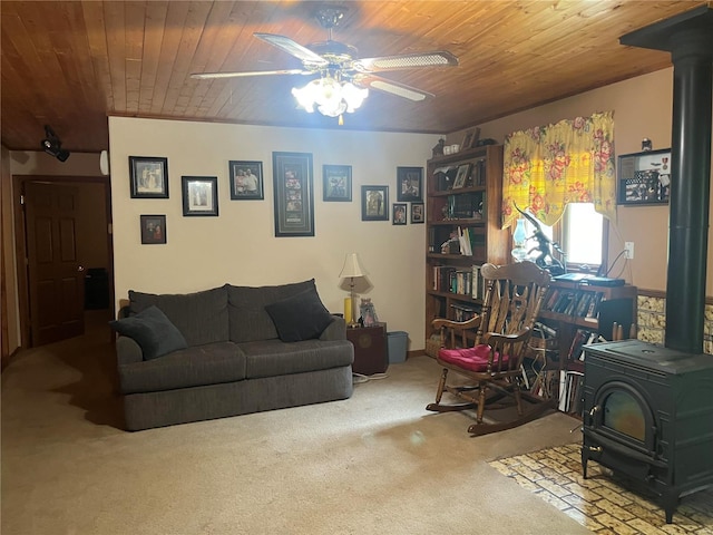 carpeted living room featuring a ceiling fan, wood ceiling, and a wood stove