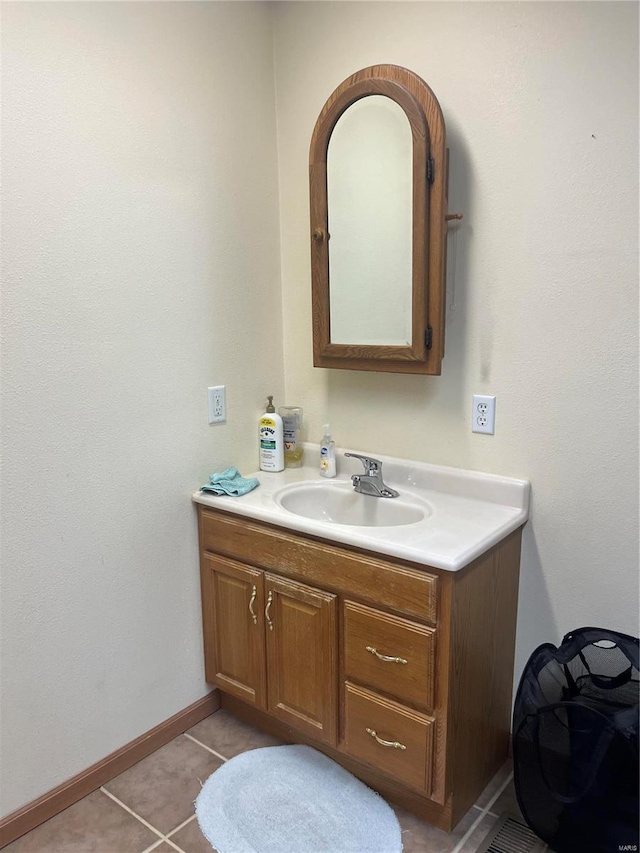 bathroom with baseboards, vanity, and tile patterned floors